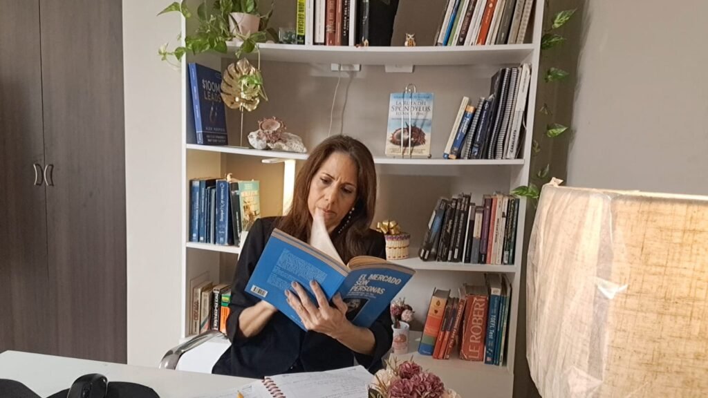 Solange Garcés Aguilar leyendo un libro en su biblioteca personal